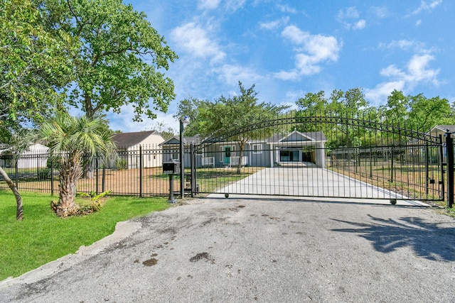 view of gate with a lawn and fence