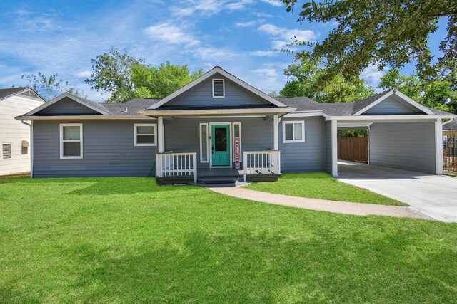 ranch-style home with covered porch, a carport, and a front lawn