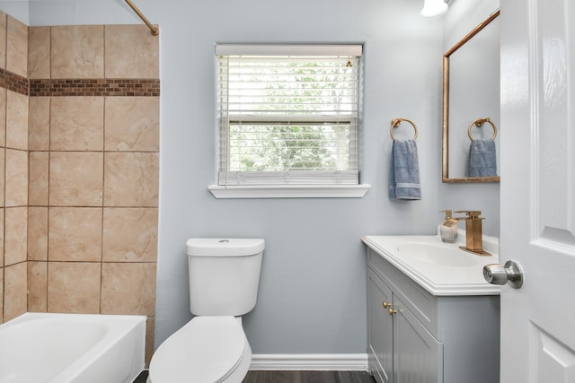 full bathroom featuring toilet, tiled shower / bath, and vanity