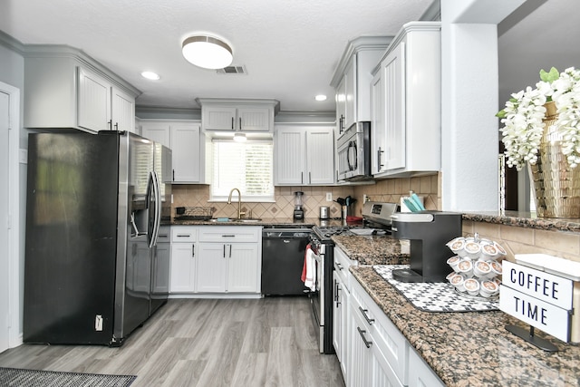 kitchen featuring tasteful backsplash, sink, dark stone countertops, and stainless steel appliances