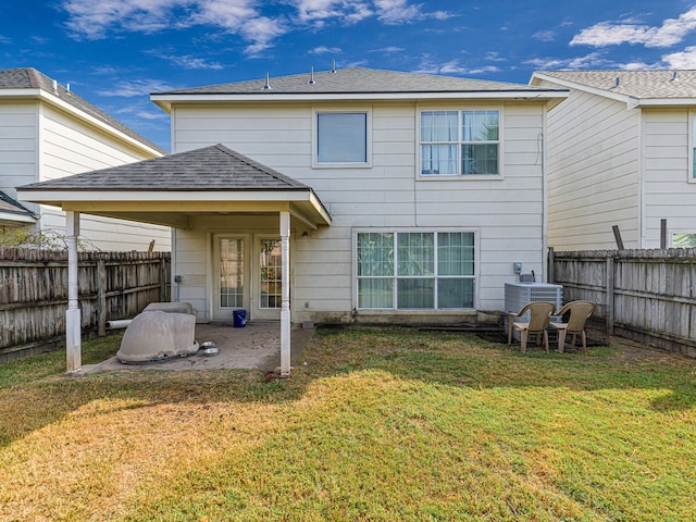 back of house featuring central AC unit, a yard, and a patio area