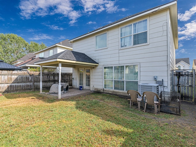 rear view of house with a patio, a yard, and cooling unit