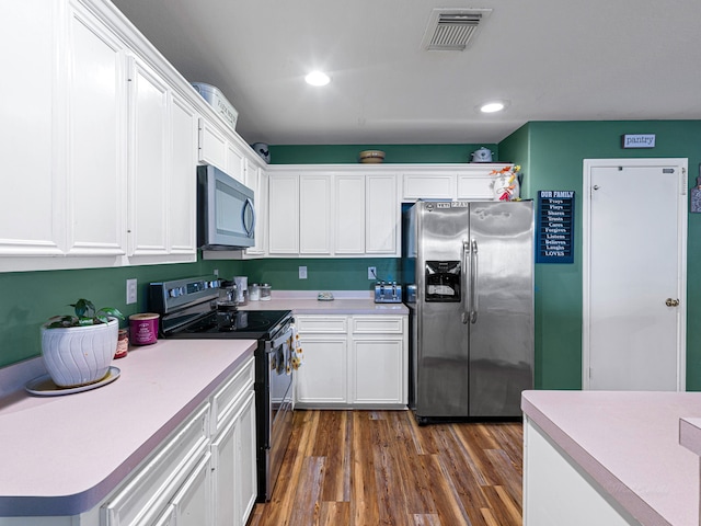 kitchen featuring white cabinets, dark hardwood / wood-style flooring, and appliances with stainless steel finishes