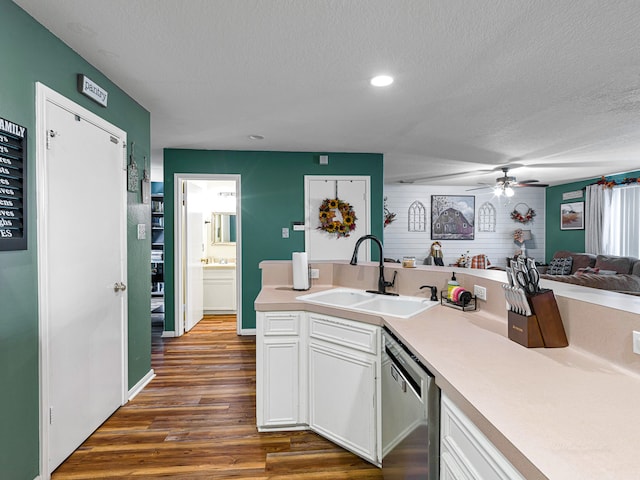 kitchen featuring dark wood-type flooring, dishwasher, white cabinets, a textured ceiling, and sink