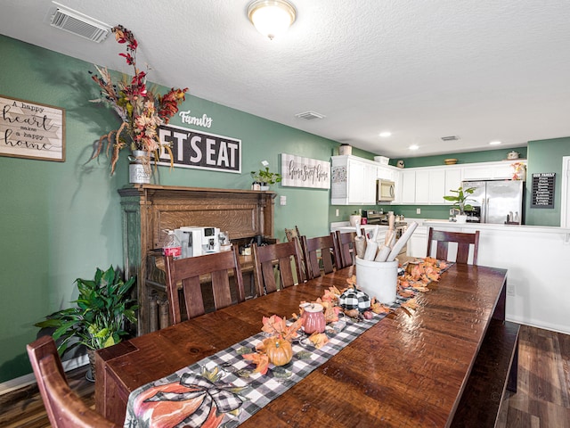 dining room with dark hardwood / wood-style flooring and a textured ceiling