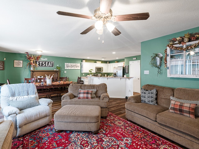 living room featuring a textured ceiling, hardwood / wood-style floors, and ceiling fan