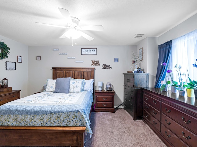 carpeted bedroom featuring ceiling fan and a textured ceiling