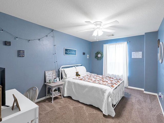 bedroom with a textured ceiling, carpet floors, and ceiling fan