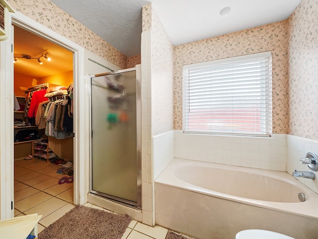 bathroom featuring plus walk in shower, a textured ceiling, and tile patterned flooring