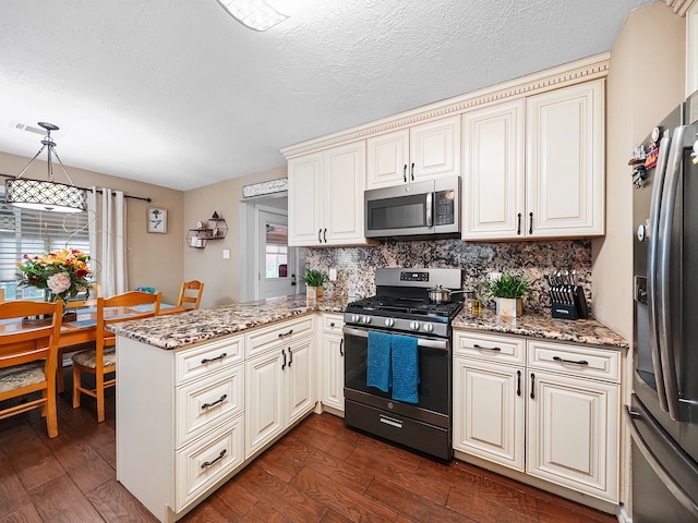 kitchen with kitchen peninsula, stone counters, dark hardwood / wood-style floors, appliances with stainless steel finishes, and decorative light fixtures