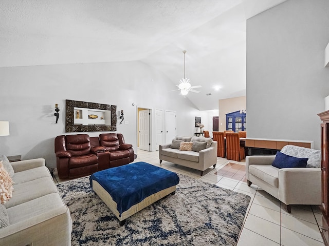 tiled living room with a textured ceiling, high vaulted ceiling, and ceiling fan