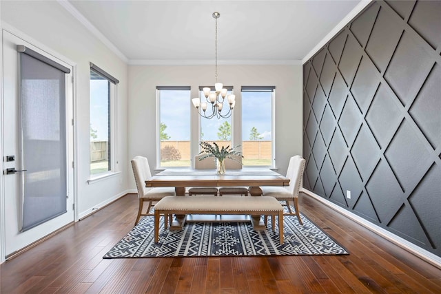 dining room featuring dark wood-type flooring, an inviting chandelier, and crown molding