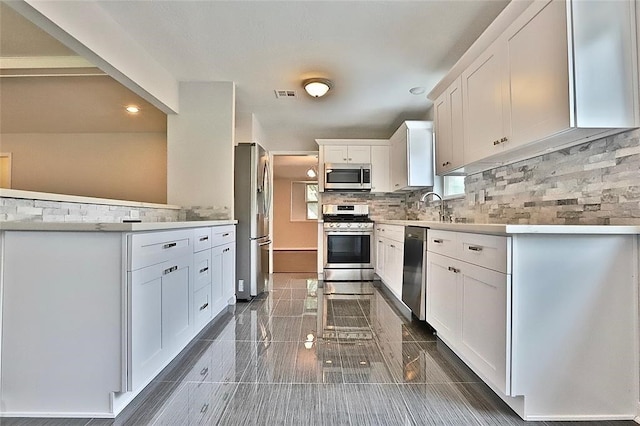 kitchen with white cabinetry, sink, appliances with stainless steel finishes, and tasteful backsplash