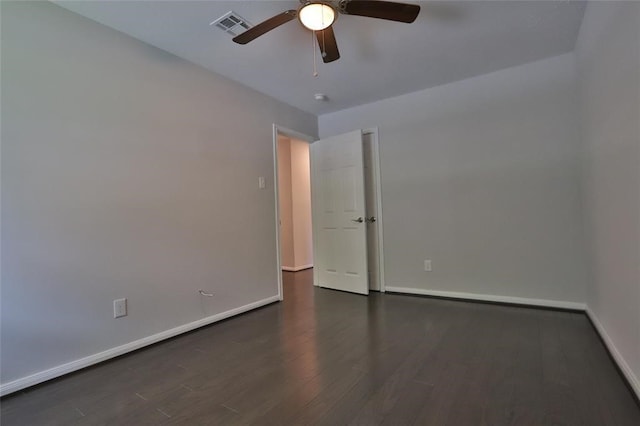 spare room with dark wood-type flooring and ceiling fan