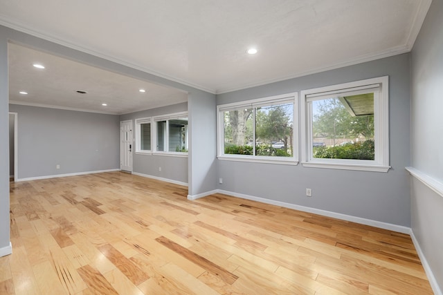 spare room featuring crown molding and light hardwood / wood-style floors