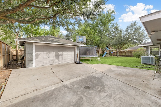 view of patio featuring central AC, a garage, a trampoline, an outbuilding, and a playground