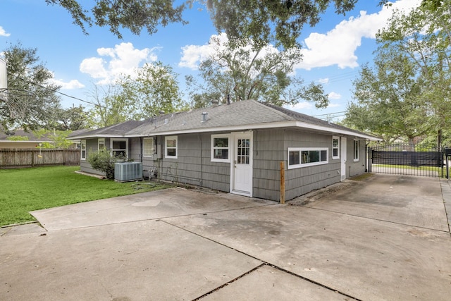 back of property featuring cooling unit and a yard