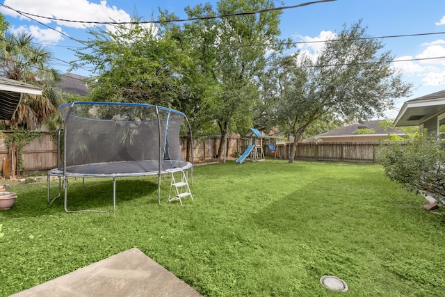 view of yard with a trampoline and a playground