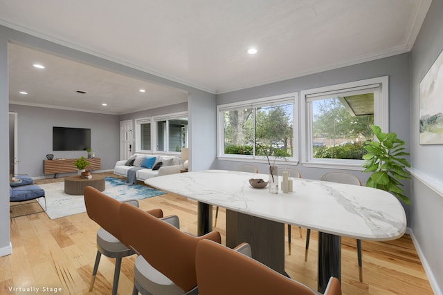 dining room featuring crown molding and light hardwood / wood-style floors