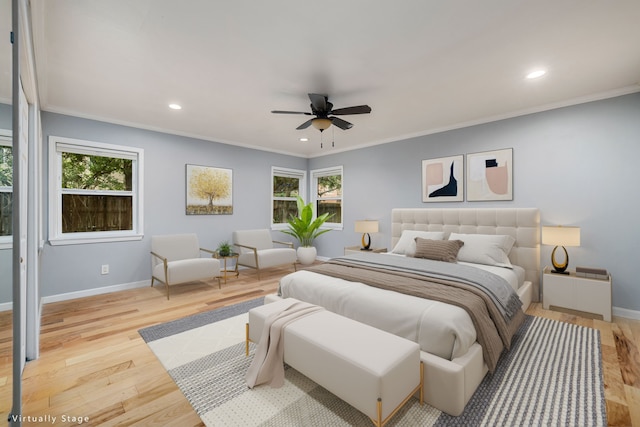 bedroom featuring multiple windows, ornamental molding, ceiling fan, and light wood-type flooring