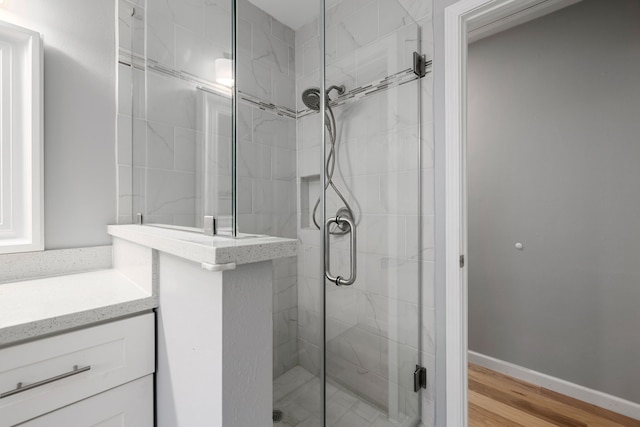 bathroom featuring a shower with door, vanity, and hardwood / wood-style flooring