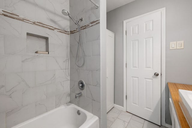 bathroom with tiled shower / bath combo and sink