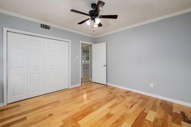 unfurnished bedroom featuring crown molding, a closet, ceiling fan, and light hardwood / wood-style flooring