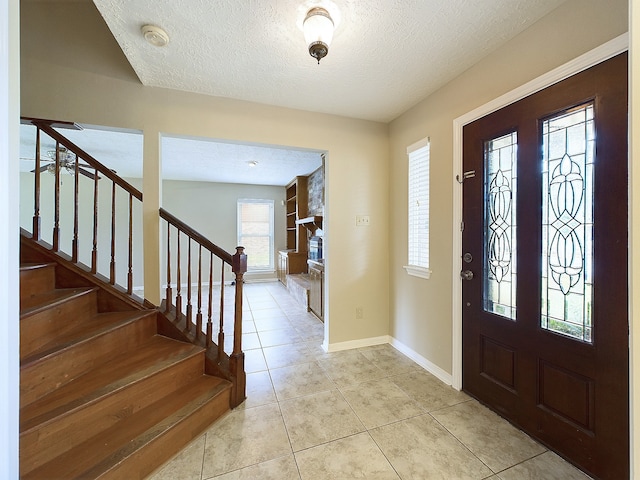 foyer with light tile patterned flooring and a textured ceiling