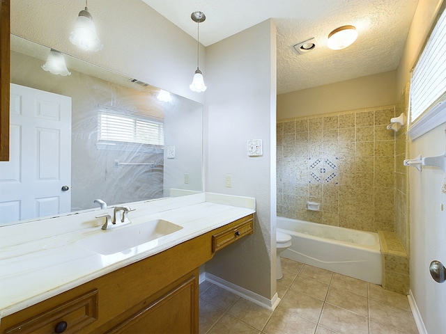 full bathroom with tile patterned floors, toilet, a textured ceiling, tiled shower / bath combo, and vanity