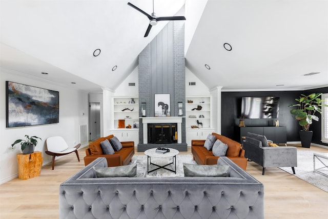 living room featuring built in shelves, ceiling fan, high vaulted ceiling, a fireplace, and light hardwood / wood-style floors