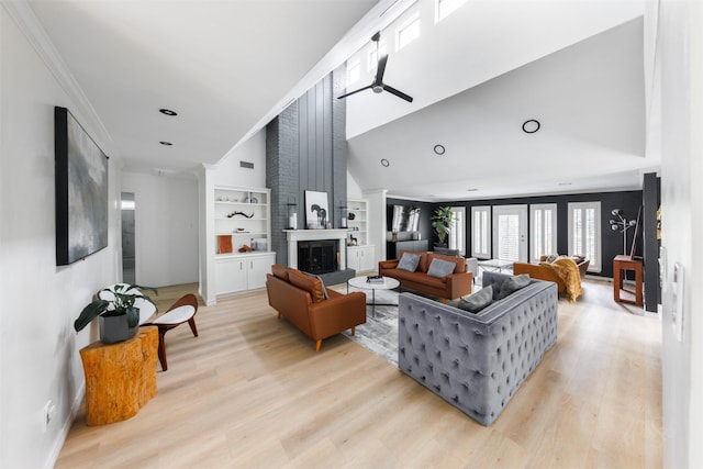 living room featuring a fireplace, light hardwood / wood-style flooring, ceiling fan, and crown molding