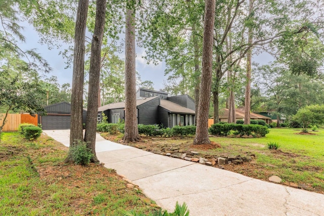 view of front of property with a front yard, an outdoor structure, and a garage