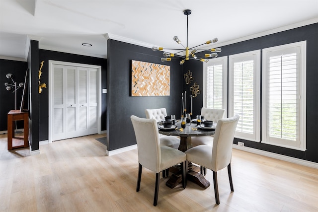 dining room featuring light wood-type flooring, crown molding, and a chandelier