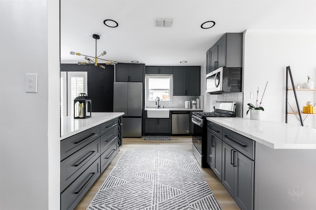 kitchen featuring backsplash, a wealth of natural light, stainless steel appliances, and decorative light fixtures