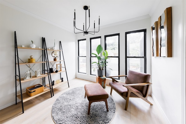 sitting room with a notable chandelier, light hardwood / wood-style floors, and ornamental molding