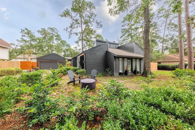 rear view of property with a garage and an outdoor structure