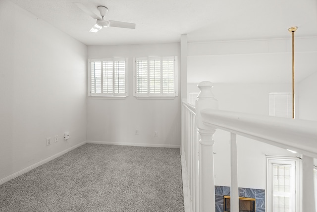 carpeted empty room featuring ceiling fan and a wealth of natural light