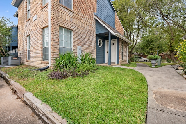 view of side of home with a yard and cooling unit