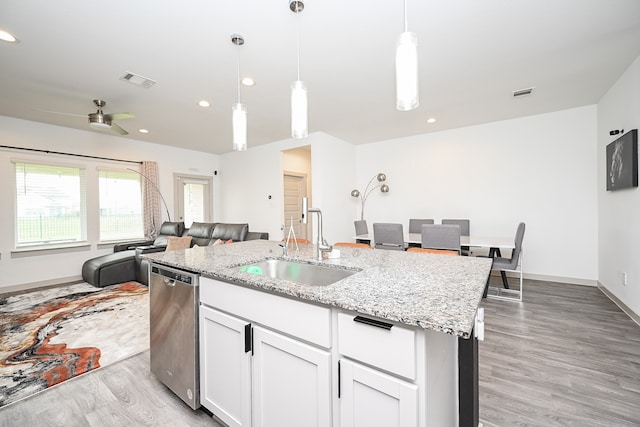 kitchen with light hardwood / wood-style floors, sink, an island with sink, white cabinets, and pendant lighting