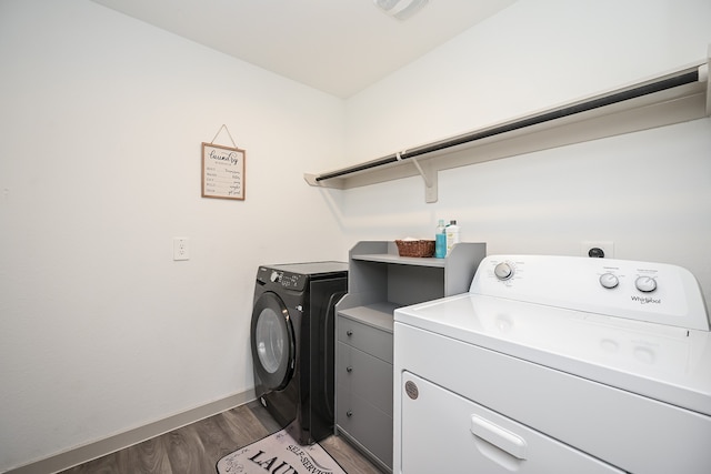 washroom featuring washing machine and dryer, cabinets, and hardwood / wood-style flooring