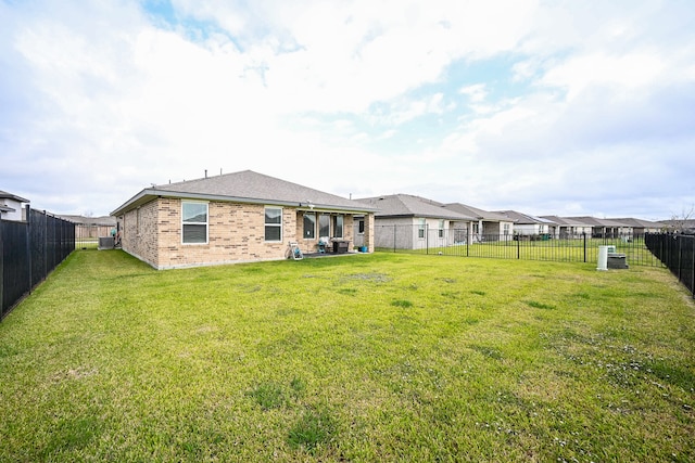 rear view of property featuring cooling unit and a lawn