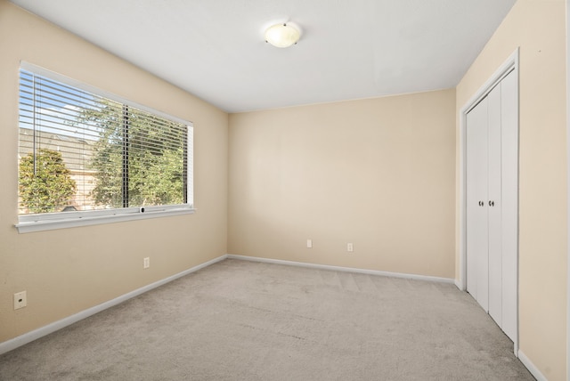 unfurnished bedroom featuring a closet and light carpet