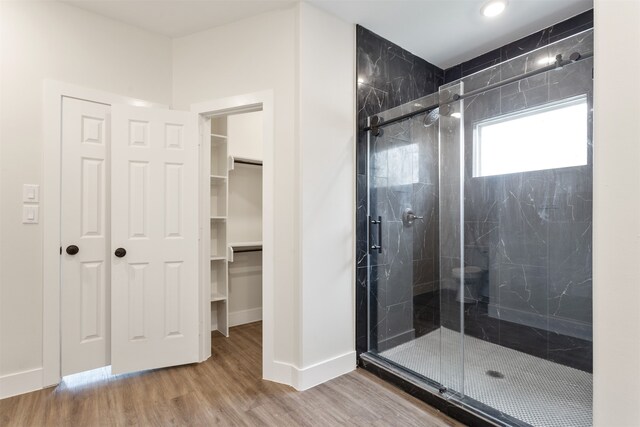 bathroom featuring wood-type flooring and a shower with shower door