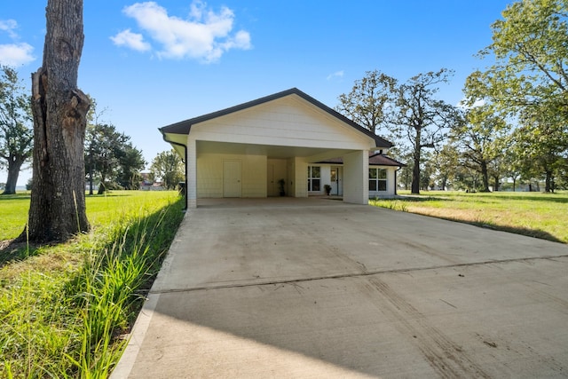 garage featuring a carport and a lawn