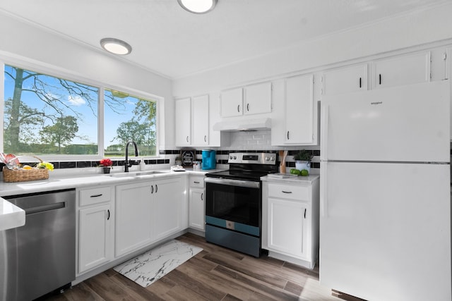 kitchen with dark wood-type flooring, sink, tasteful backsplash, white cabinetry, and stainless steel appliances