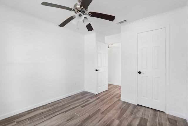 interior space with hardwood / wood-style floors, ceiling fan, and crown molding