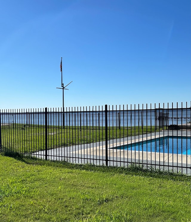 exterior space featuring a fenced in pool, a yard, and a water view