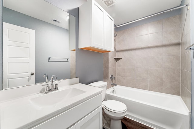 full bathroom with vanity, tiled shower / bath combo, and toilet