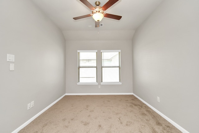 empty room featuring light colored carpet, ceiling fan, and vaulted ceiling