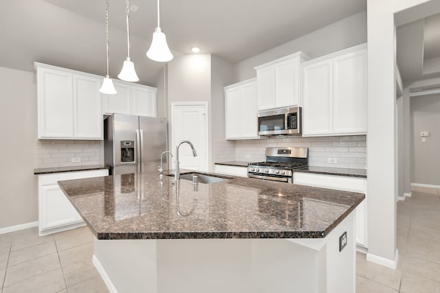 kitchen featuring white cabinets, stainless steel appliances, sink, and an island with sink